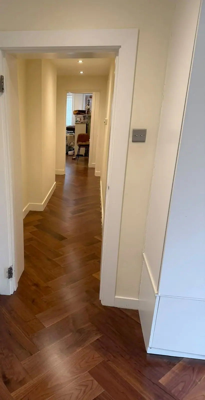 Walnut herringbone floor running the length of a hallway